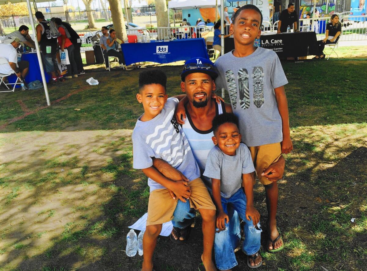 Yerodin Prince, 40, shown with his three sons, hopes to open a real estate business with his wife. But because of two felonies he was convicted of in his 20s, he can't obtain the professional license he needs.