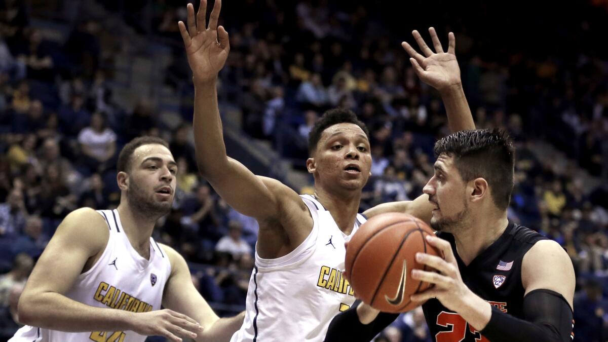 California's Ivan Rabb, center, and teammate Kameron Rookstry to prevent Oregon State's Gligorije Rakocevic from scoring during the second half Friday night.