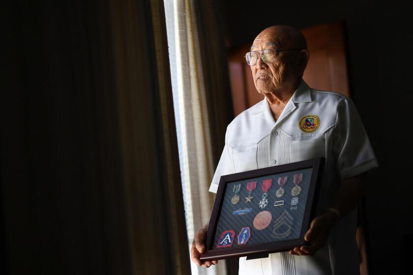Tokuji Yoshihashi, 94, is photographed with his collection of medals at home in San Gabriel. Exactly 75 years ago Sunday, President Franklin D. Roosevelt signed Executive Order 9066, which paved the way for the incarceration of Yoshihashi and 120,000 other Japanese Americans