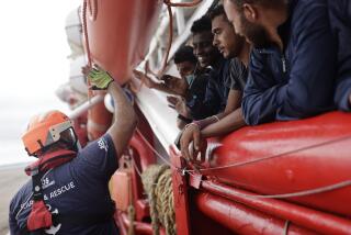 ARCHIVO - Un voluntario de SOS Mediterranee choca la mano con un migrante mientras se acercan a las costas italianas el 4 de septiembre de 2022 cerca de Taranto, en el sur de Italia. (AP Foto/Jeremias Gonzalez, Archivo)