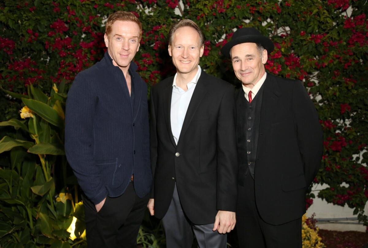 From left to right, Damian Lewis, British Consul General Christopher O'Connor and Mark Rylance pose at a Jan. 18 tea in Los Angeles honoring the "Masterpiece" production of "Wolf Hall."