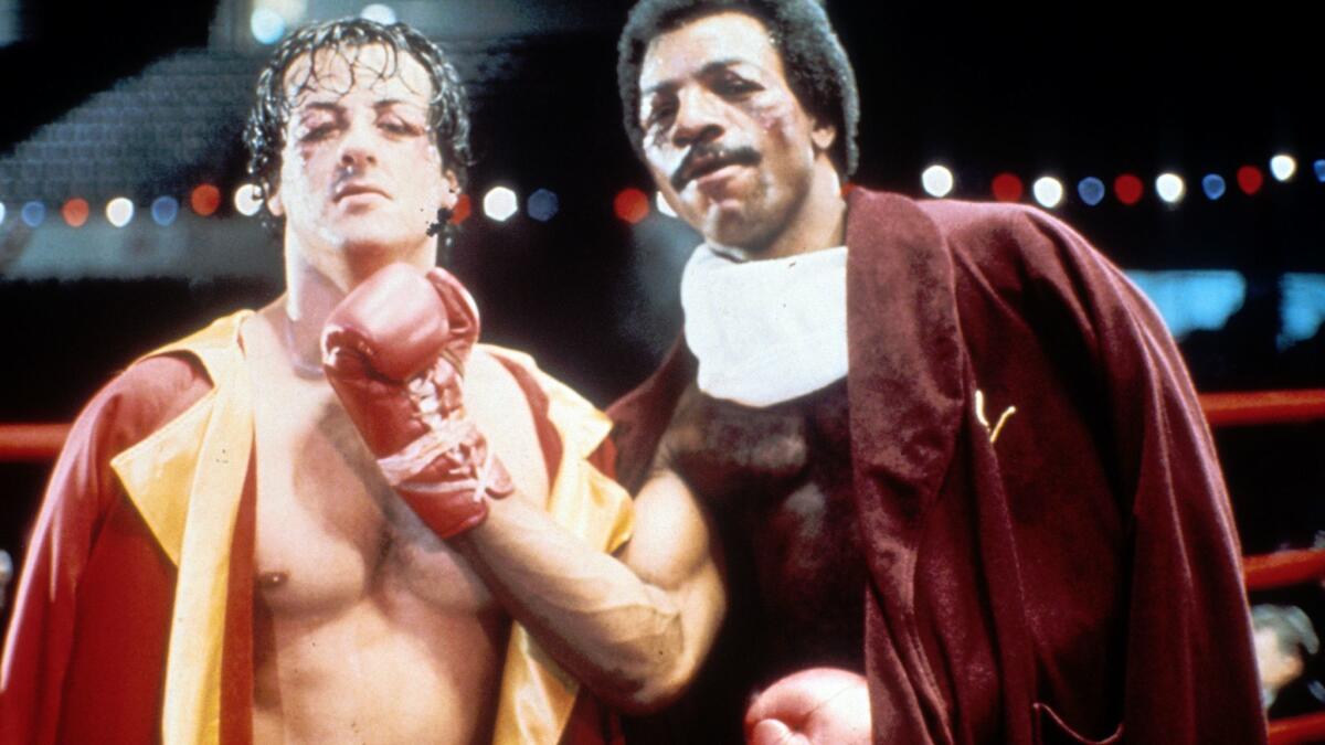 Sylvester Stallone, left, and Carl Weathers on the set of "Rocky" in 1976.
