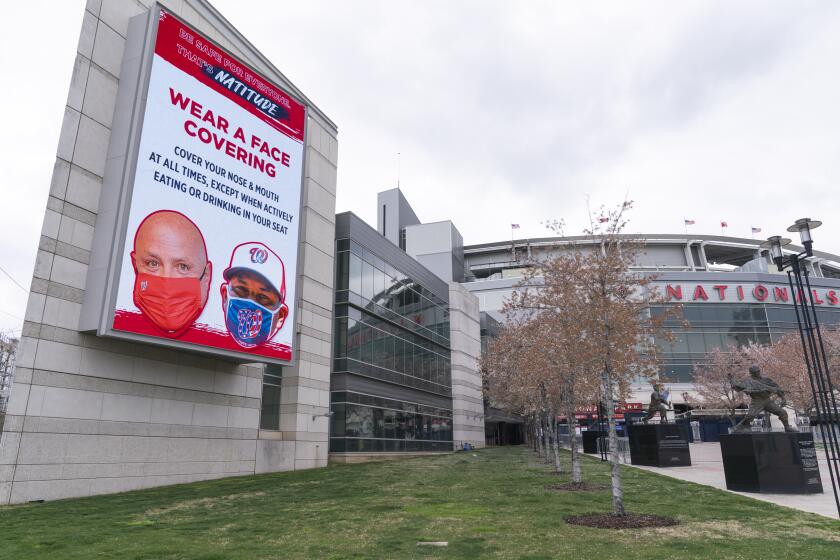 An electronic sign encouraging mask wearing is seen at Nationals Stadium, after the opening day baseball game between the Washington Nationals and New York Mets was postponed because of coronavirus concerns, Thursday, April 1, 2021, in Washington. (AP Photo/Jacquelyn Martin)