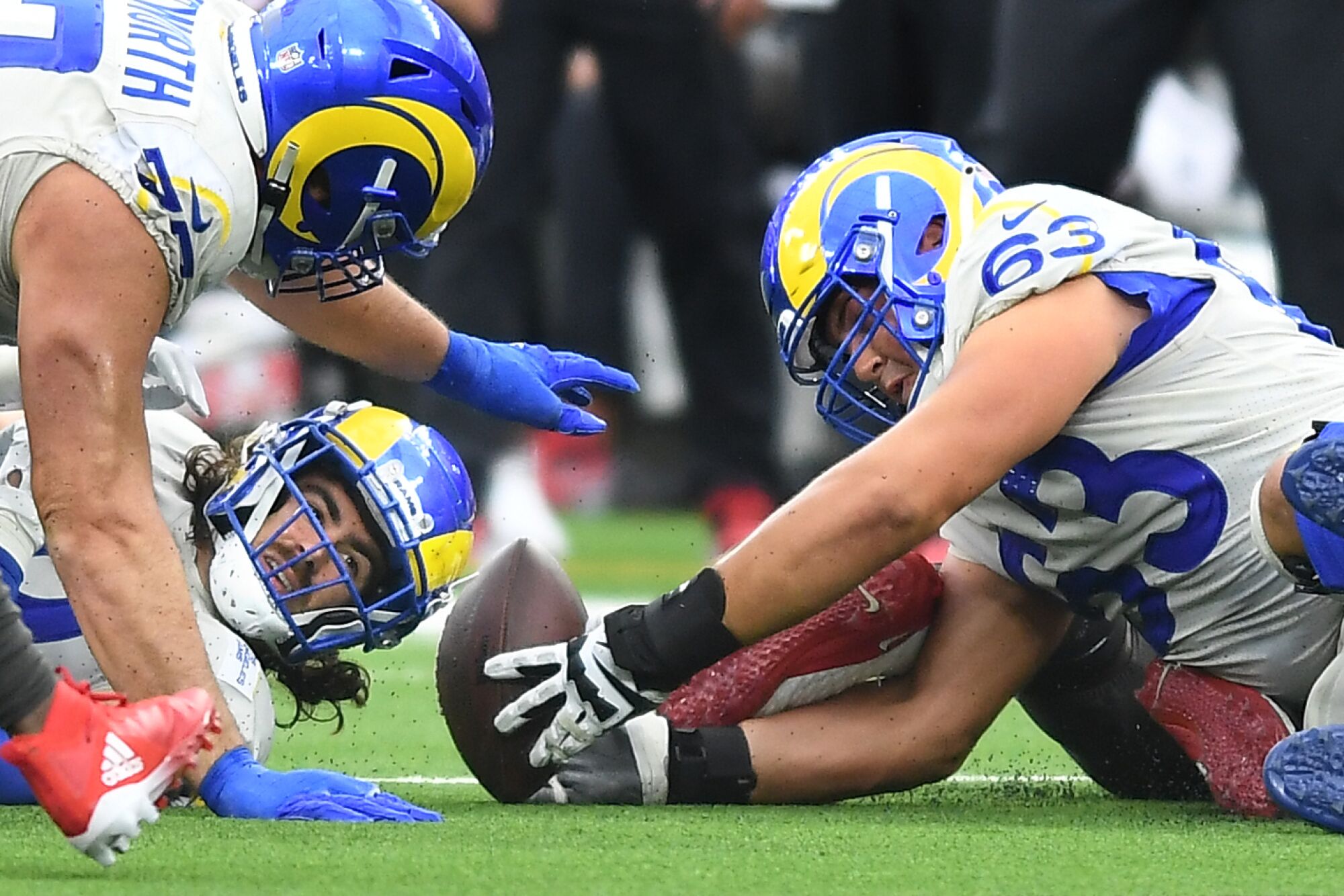 Rams tight end Tyler Higbee fumbles, but offensive linemen Rob Havenstein and Austin Corbett help recover the ball.