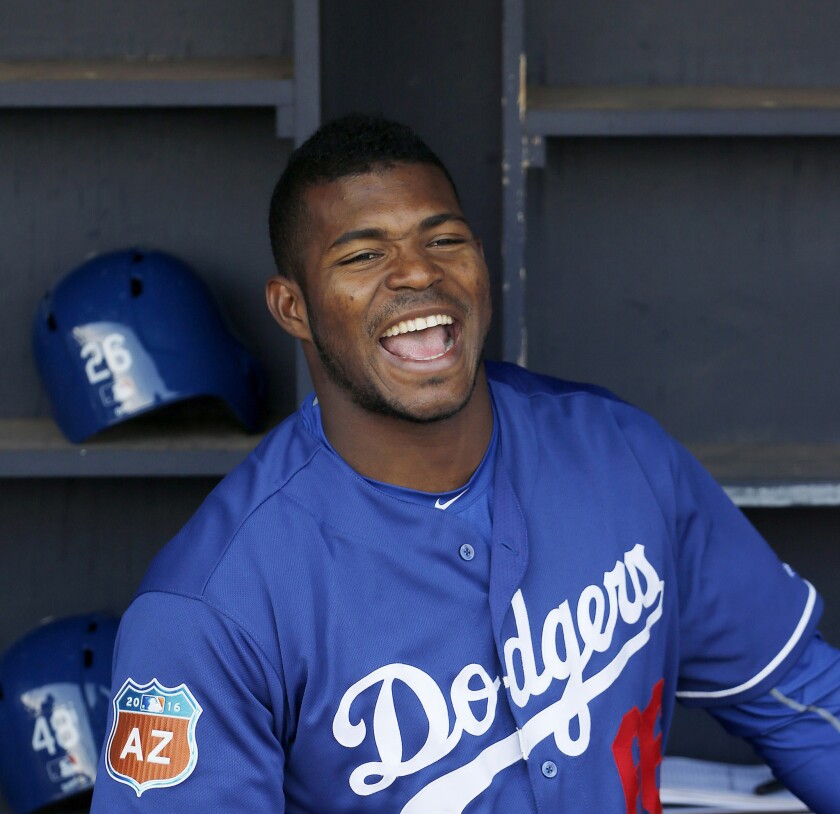 Dodgers outfielder Yasiel Puig laughs with teammates prior to a spring training game against the Padres, in Peoria, Ariz on Mar. 29.