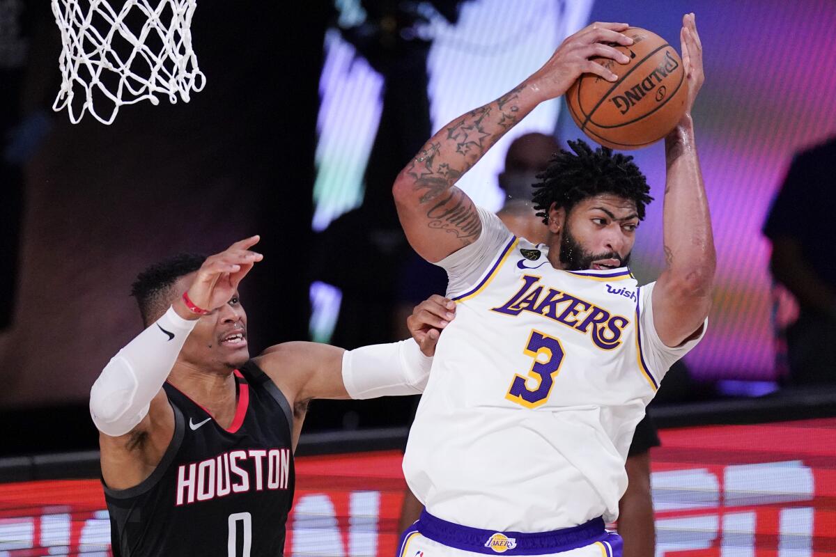 Lakers forward Anthony Davis grabs a rebound over the Rockets guard Russell Westbrook during the second half of Game 5.