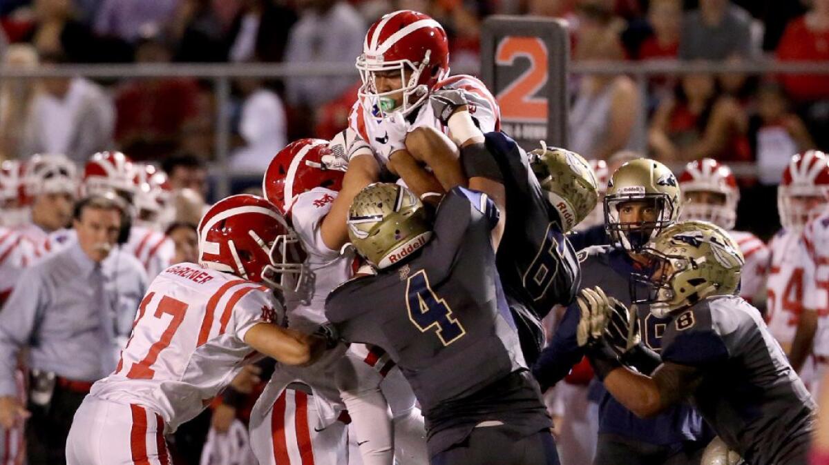 Mater Dei receiver Amon-Ra St. Brown is lifted into the air by the St. John Bosco defense during the first half of a game on Oct. 21.