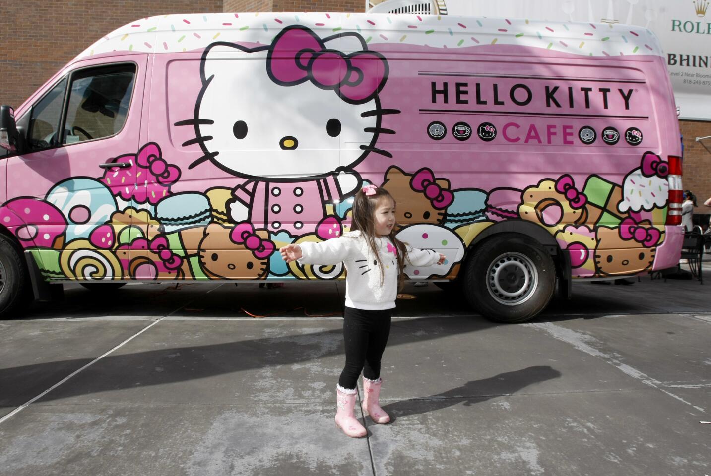 Summer Young, 3 of Glendale, strikes a pose in front of the Hello Kitty Cafe truck, parked at the Glendale Galleria on Central Ave., in Glendale on Saturday, Feb. 11, 2017. The cafe sells Hello Kitty items, including freshly-made doughnuts. The cafe travels throughout the country and was last in Glendale one year ago.