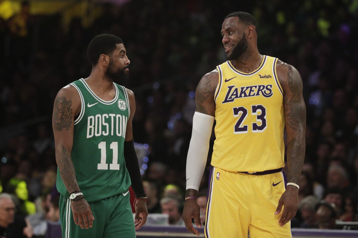 Lakers forward LeBron James chats with then Celtics guard Kyrie Irving.