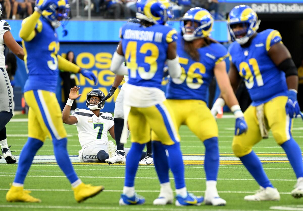 Seahawks quarterback Geno Smith watches as the Rams react to breaking up a pass.