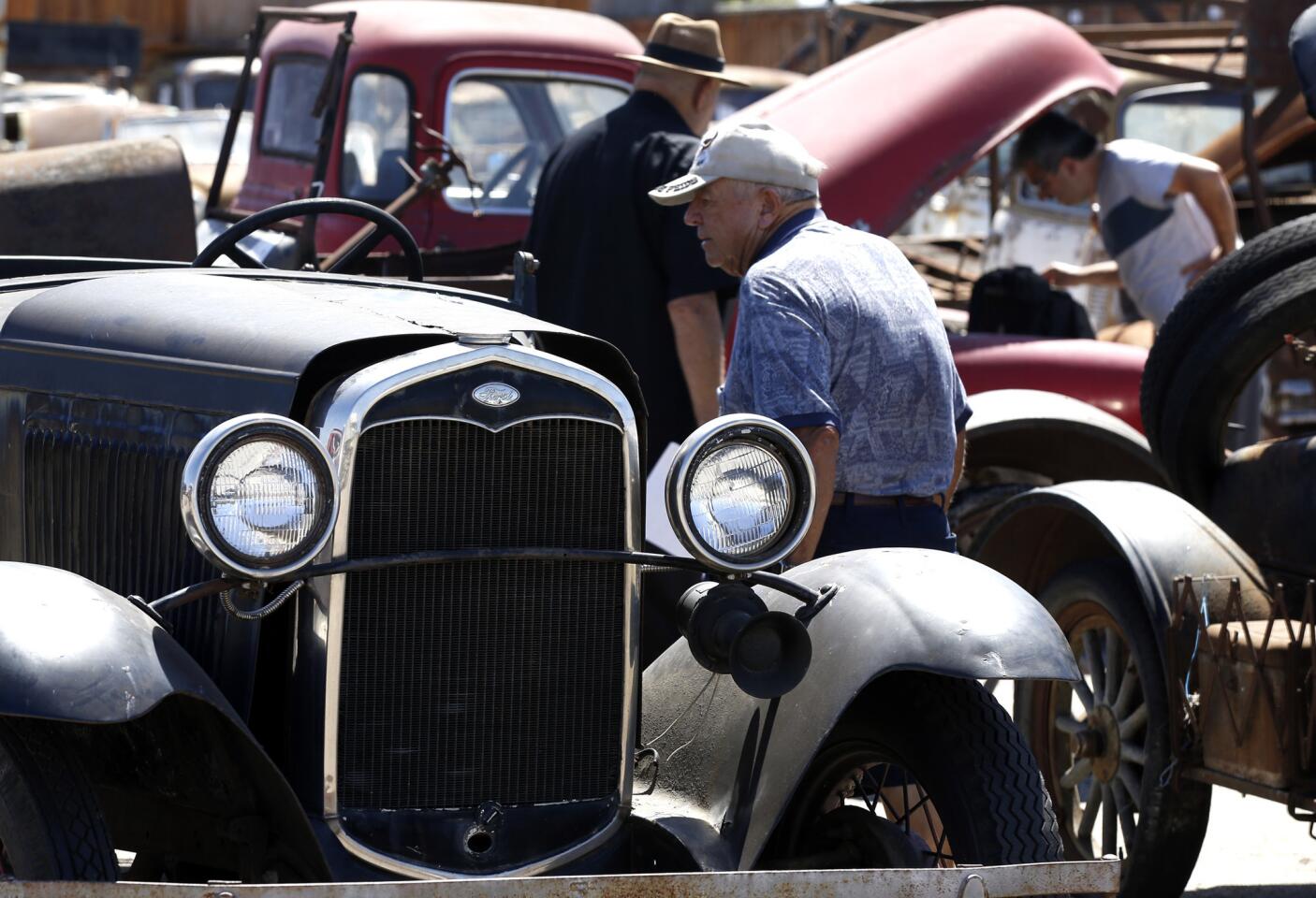 Prospective buyers turn out to place their bids on dozens of collectible cars, car parts, tractors and a small plane at an auction in Santa Ana on Tuesday.