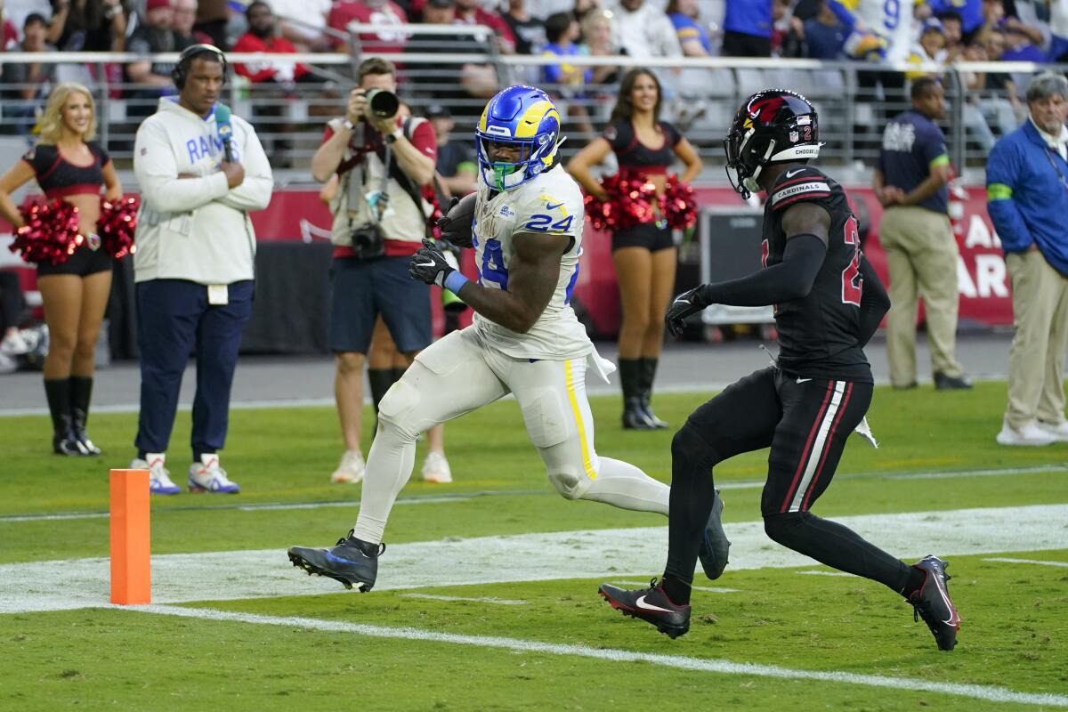 The Rams' Royce Freeman completes a 23-yard run for a touchdown as Cardinals cornerback Divaad Wilson pursues too late. 