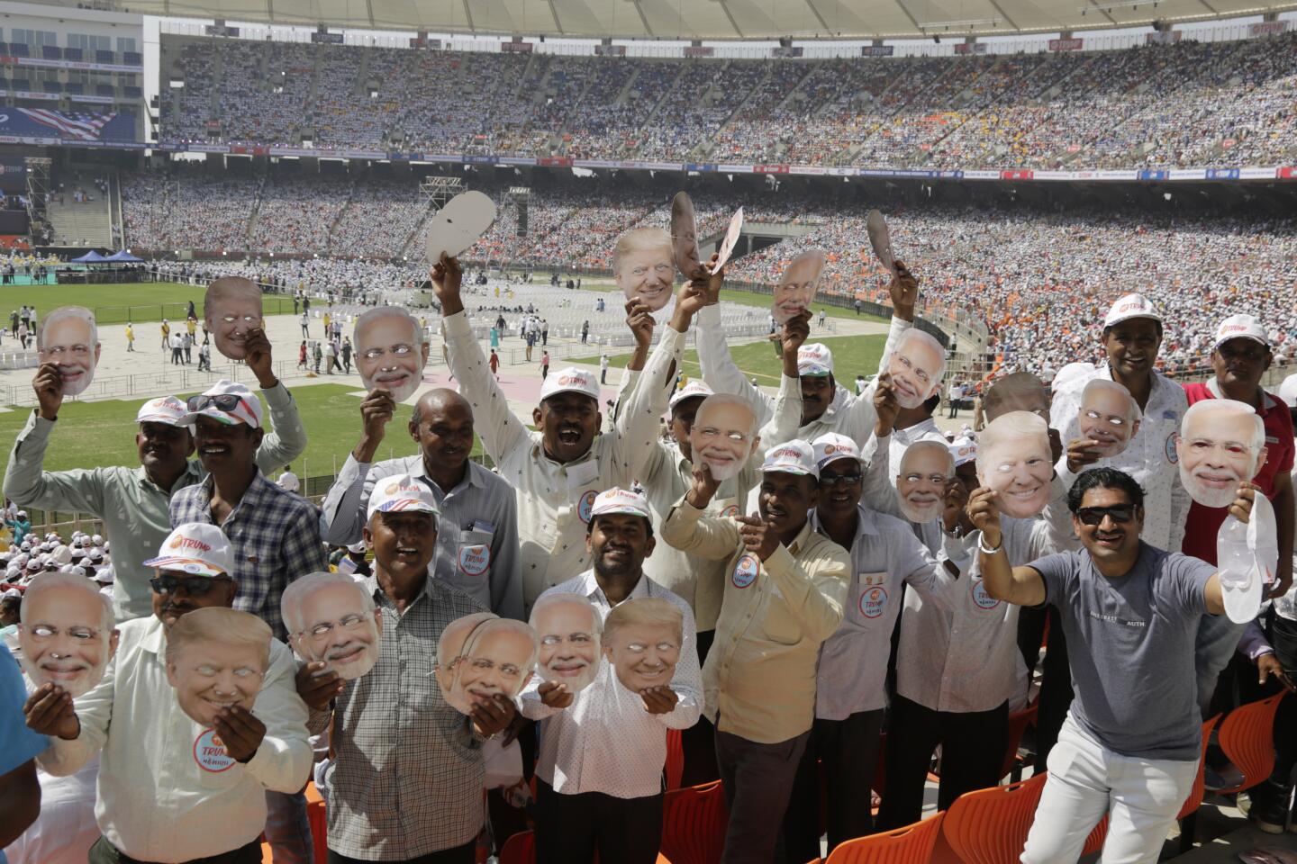Masks of Trump and Modi are displayed by rally attendees before the start of the event.