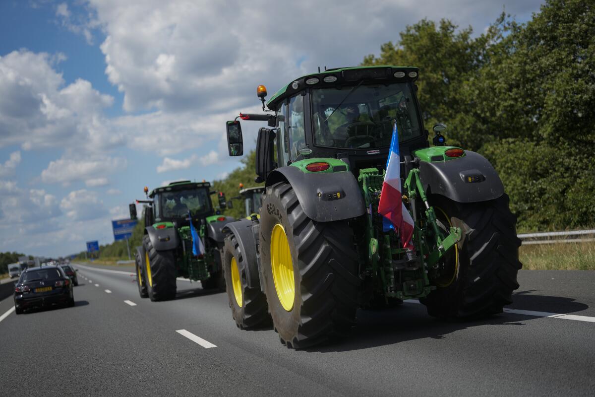 Demonstrating farmers slow down traffic on a motorway near Venlo, southern Netherlands, Monday, July 4, 2022. Dutch farmers angry at government plans to slash emissions used tractors and trucks Monday to blockade supermarket distribution centers, the latest actions in a summer of discontent in the country's lucrative agricultural sector. (AP Photo/Thibault Camus)