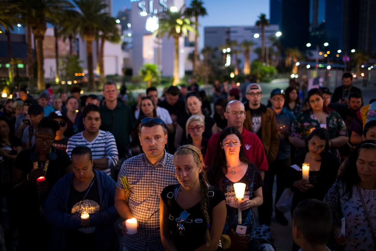 Mourners attend a candlelight vigil at the corner of Sahara Avenue and Las Vegas Boulevard for the victims of Sunday night's mass shooting. It was one of several commemorative events in Las Vegas.