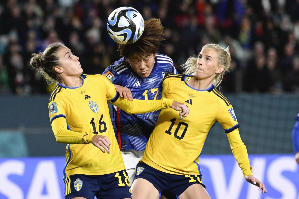 La japonesa Hana Takahashi (centro) intenta cabecear la pelota entre las suecas Filippa Angeldal 