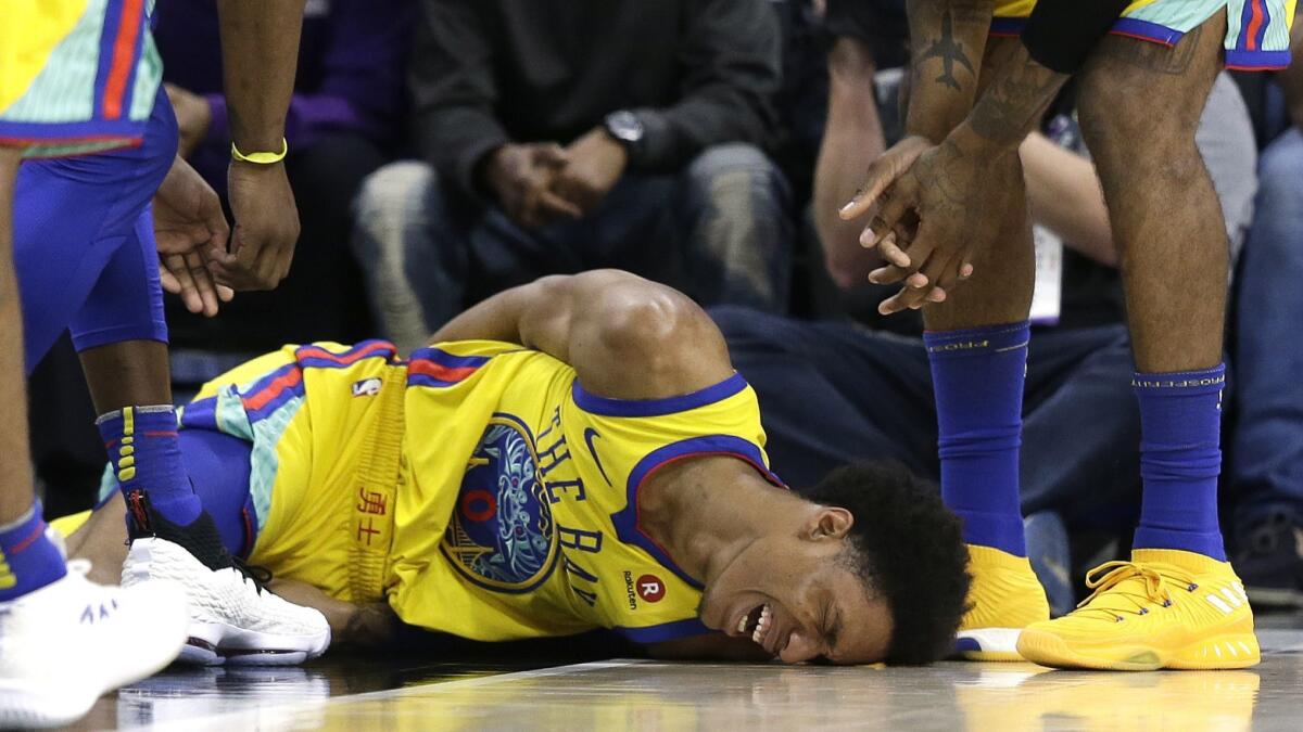 Warriors guard Patrick McCaw lays on the court in pain after falling hard to the court late in the third quarter Saturday.
