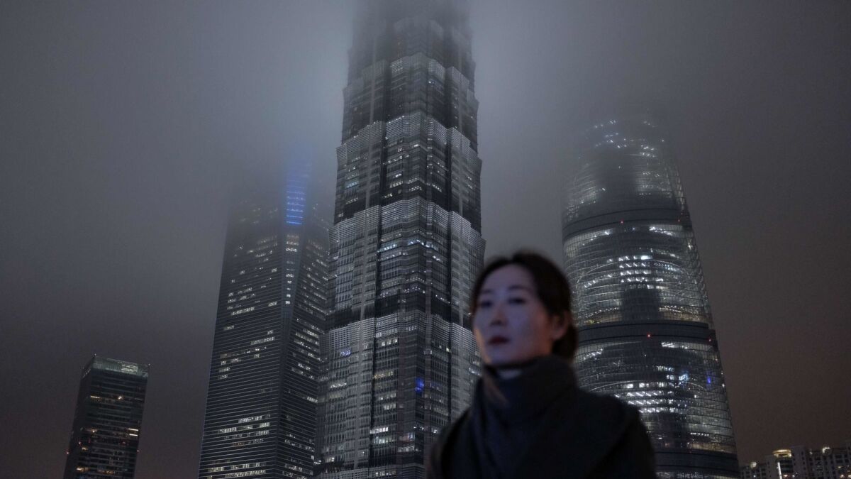 A woman walks in Shanghai's Lujiazui financial district this month. Chinese policymakers are struggling to turn around the rapidly weakening economy, with growth at its lowest since the global financial crisis a decade ago.