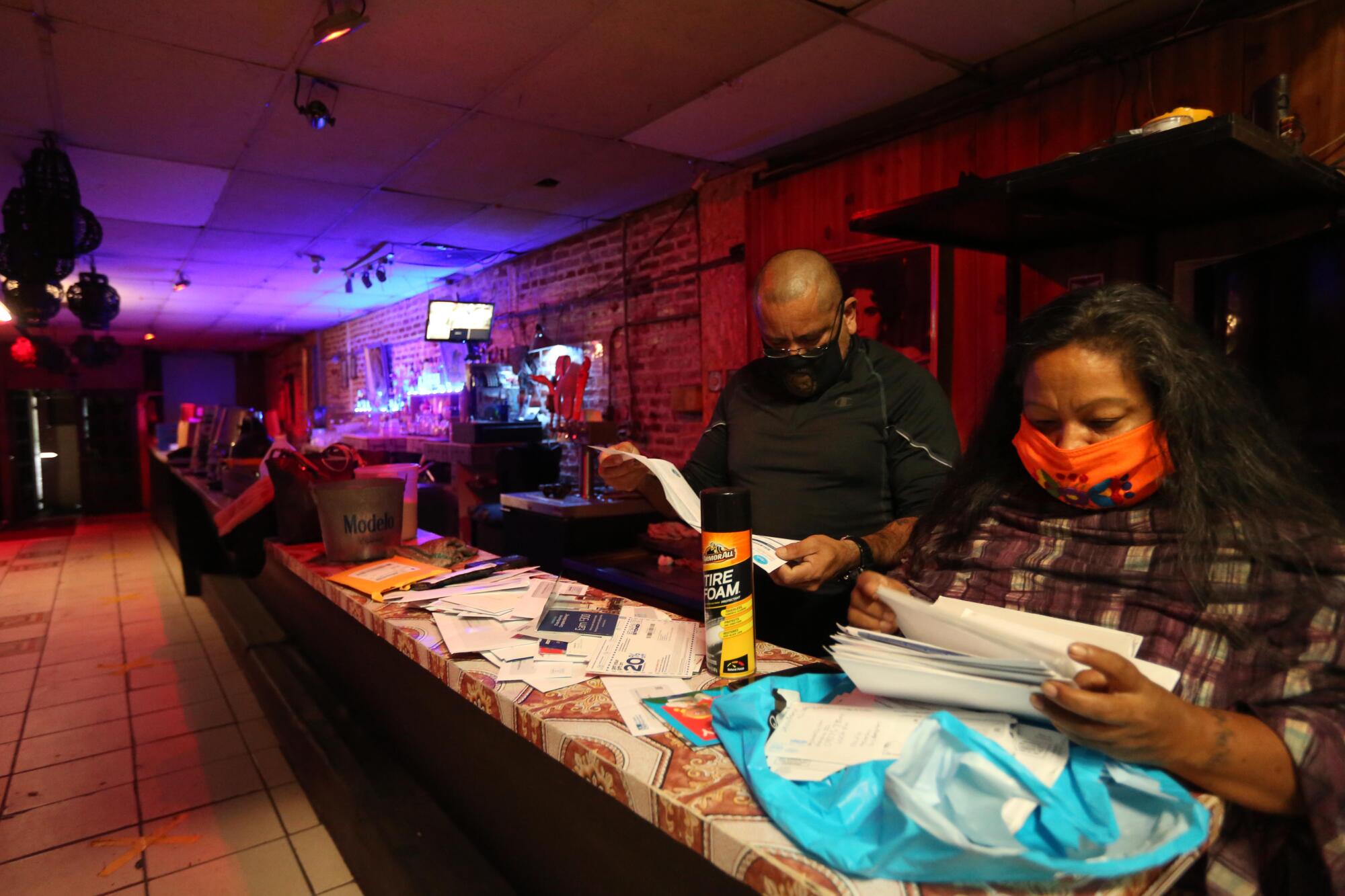 Sergio Hernandez and Maria Rosa Garcia look over bills.