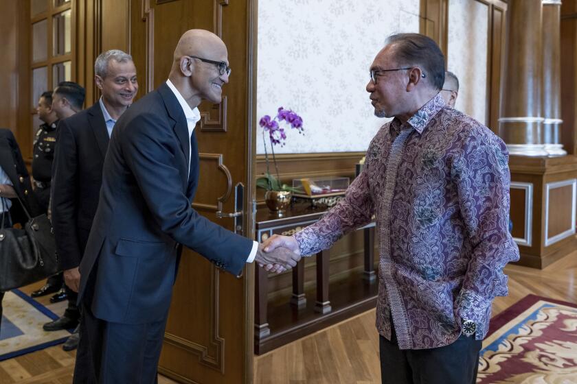 In this photo provided by Malaysia Prime Minister Office, Malaysia's Prime Minister Anwar Ibrahim, right, shakes hands with Microsoft CEO Satya Nadella at the prime minister's office in Putrajaya, Malaysia, Thursday, May 2, 2024. (Albarra Azfar/Prime Minister's Office of Malaysia via AP)