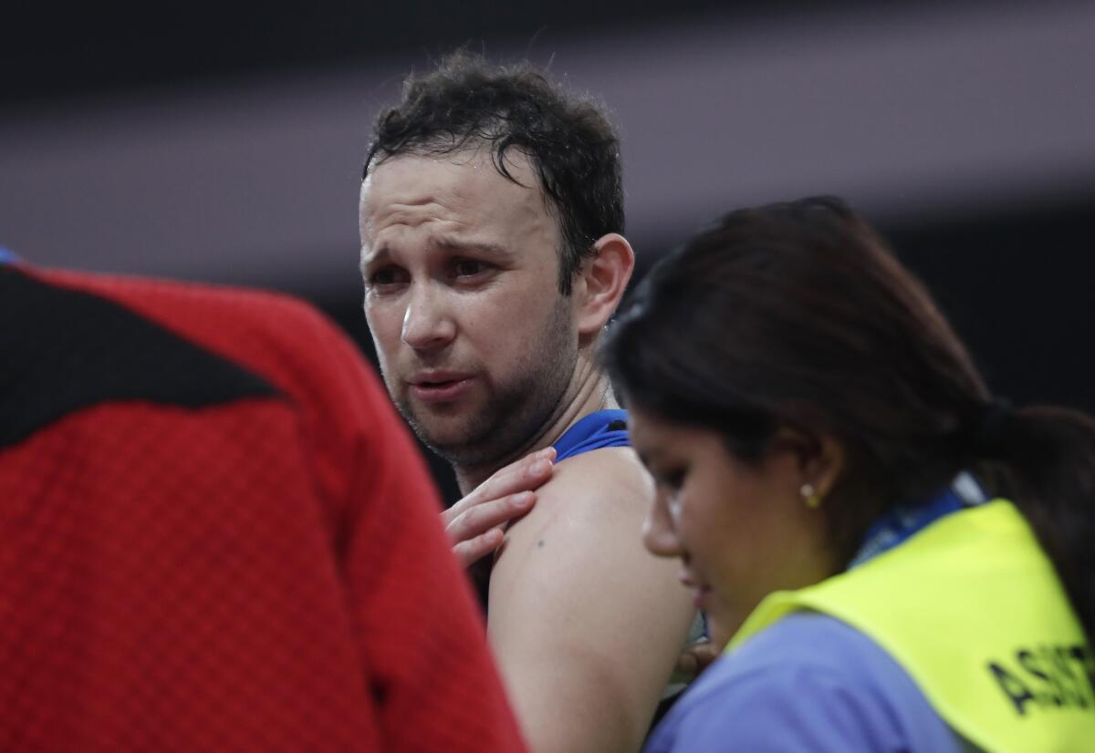 Guatemala's Kevin Cordon touches his shoulder during the badminton men's singles semi-final against Canada's Brian Yang at the Pan American Games in Lima, Peru, Thursday, Aug. 1, 2019. Cordon retired from the match after claiming an injured shoulder. (AP Photo/Silvia Izquierdo)