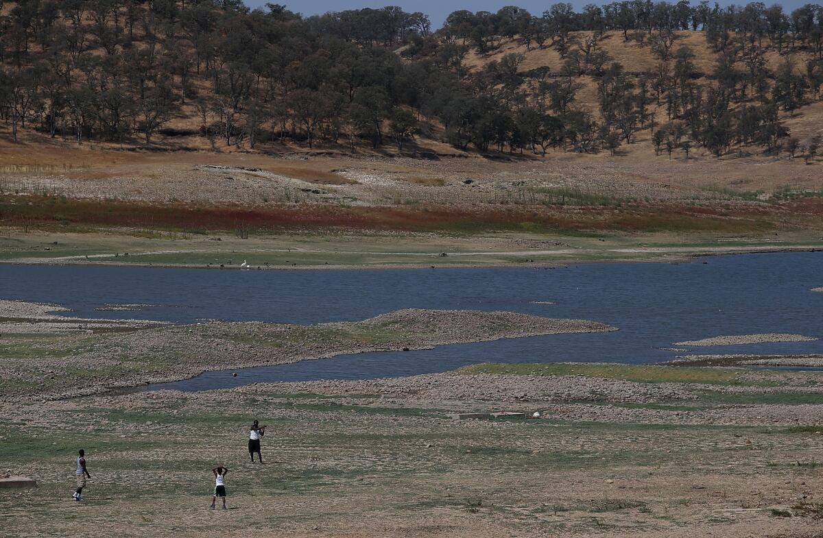 California lawmakers and Gov. Jerry Brown's administration are hoping to capitalize on the current parched conditions to pass a plan for a groundwater management system. Above, visitors play football in the depleted Camanche Reservoir.
