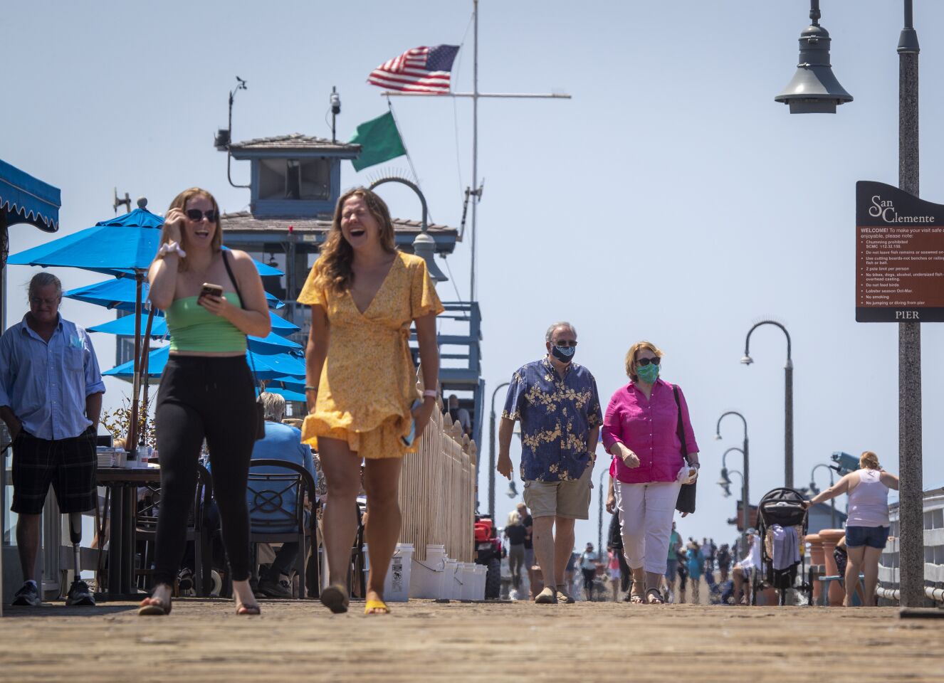 People walk on the San Clemente pier