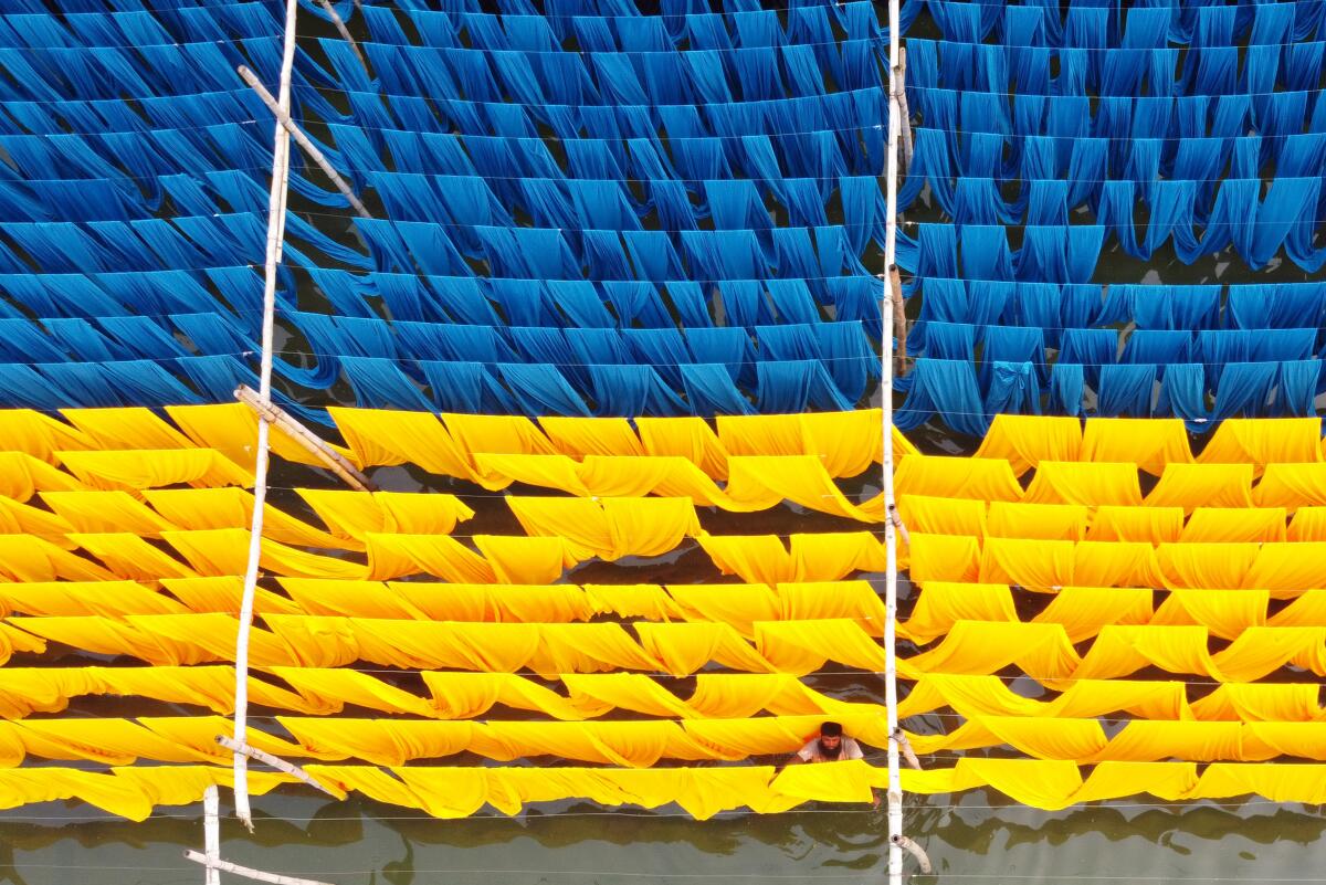 An aerial view of fabrics hung to dry after being dyed blue and yellow