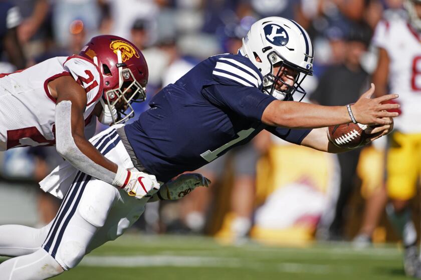 BYU quarterback Zach Wilson (1) dives into the end zone for a touchdown late in the second half as Southern California safety Isaiah Pola-Mao (21) tries to tackle him during an NCAA college football game, Saturday, Sept. 14, 2019, in Provo, Utah. (AP Photo/George Frey)