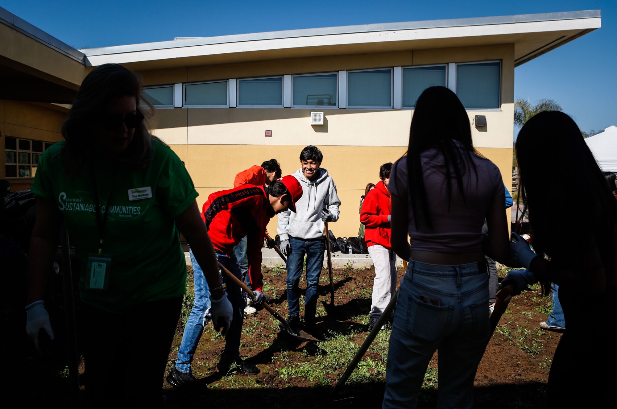Southwest Middle School student Christian Munoz laughs as he and fellow students work to create a community garden