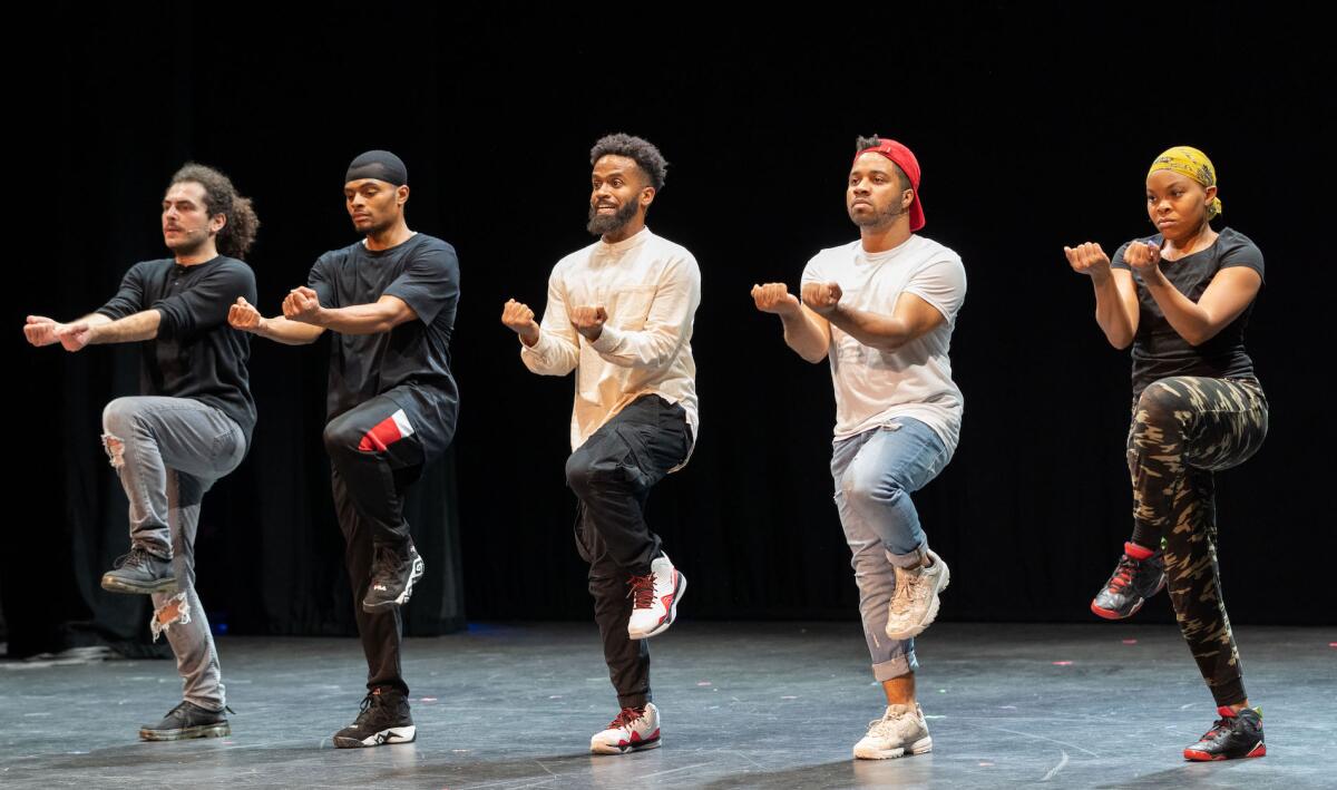 Four men and one woman dance onstage 