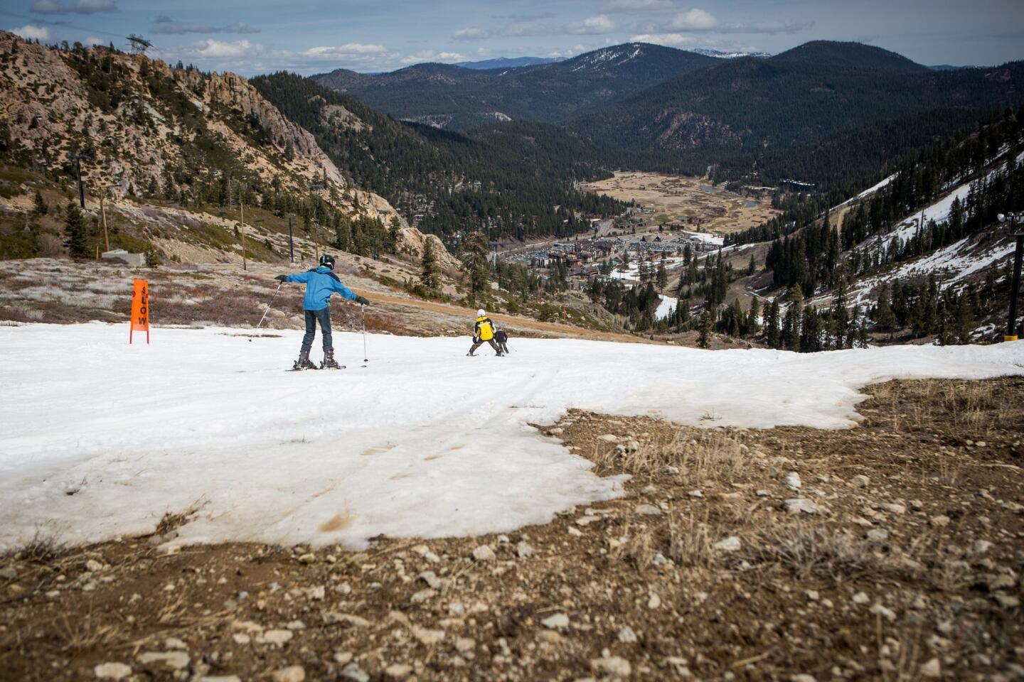 Skiers make their way around patches of dirt at Squaw Valley Ski Resort.