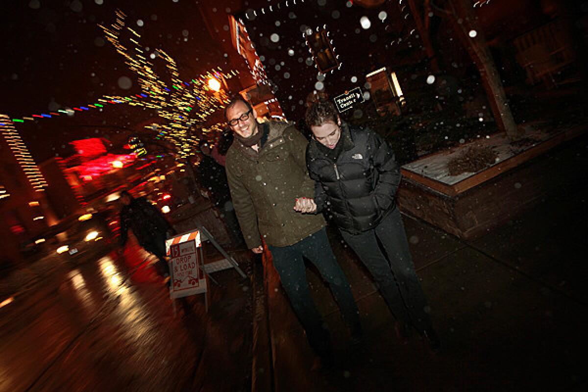 During a steady snowfall, Nicholas McCarthy and his wife Alexandra McCarthy make their way up Main Street in Park City, UT., toward the Egyptian Theatre, for the premier of his feature¿length horror film "The Pact."