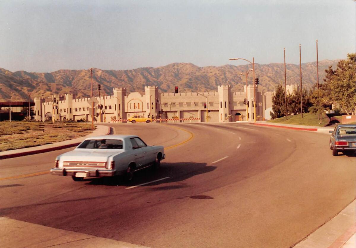 An old photo of one of the Burbank castles, with hills in the background