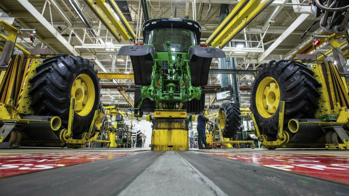 Workers assemble a tractor at the John Deere plant in Waterloo, Iowa.