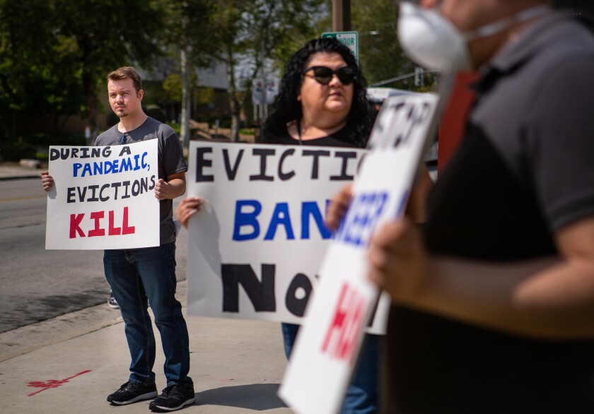 People hold signs about evictions.