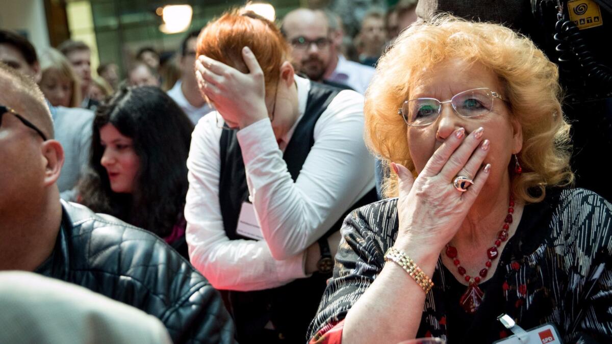 Supporters of the German Social Democrats react after the first exit polls of the state elections in Schleswig-Holstein are announced on May 7, 2017 in Berlin.