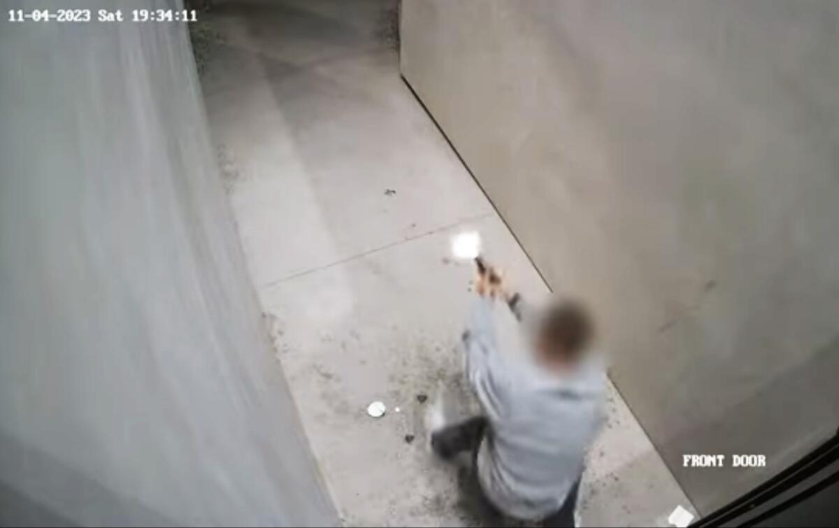 Seen from above, between two concrete walls, a man fires a gun.