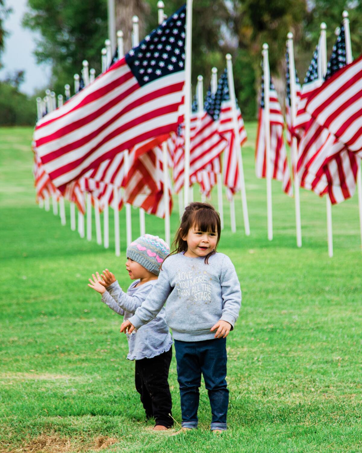 Children Wednesday play in a field of flags during a Flag Day celebration in Irvine's Mason Park.