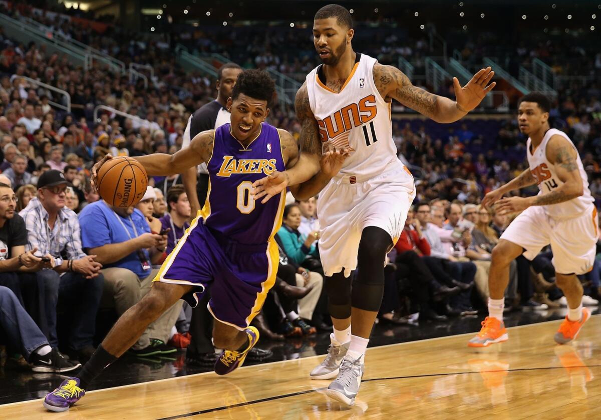 Lakers guard Nick Young tries to drive past Suns forward Markieff Morris in the first half Monday night in Phoenix.