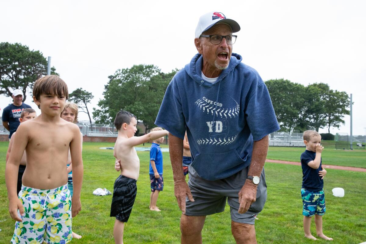 Coach Scott Pickler yells as children participating in a youth camp go through a slip and slide.