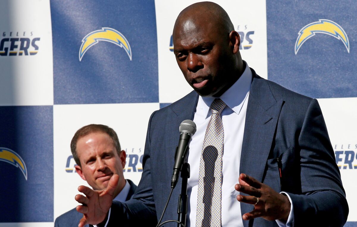 New Chargers Coach Anthony Lynn, right, talks with reporters during a news conference to announce his hiring on Jan. 17 at StubHub Center in Carson.