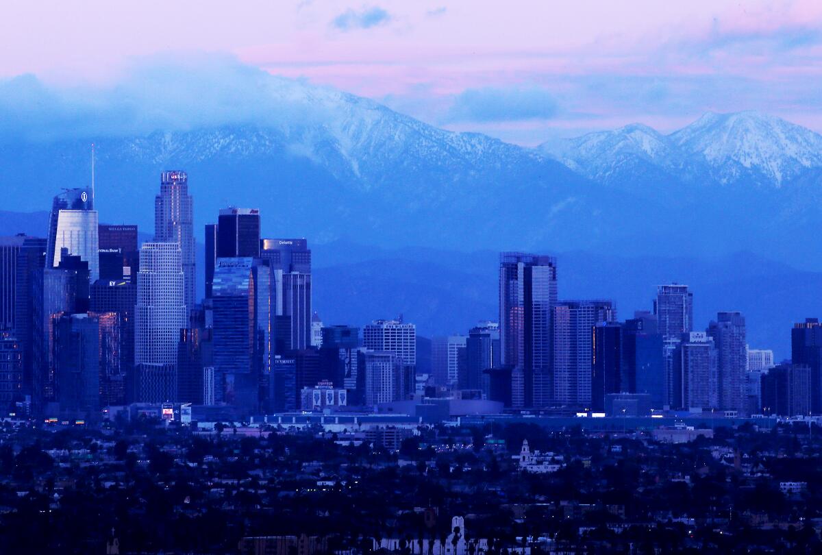  Snow-covered San Gabriel Mountains provide a   backdrop for   downtown L.A. 