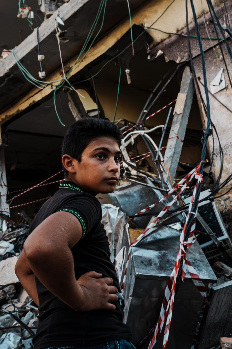 A boy stands in front of a building destroyed by an Israeli assault near a refugee camp in the Occupied West Bank.
