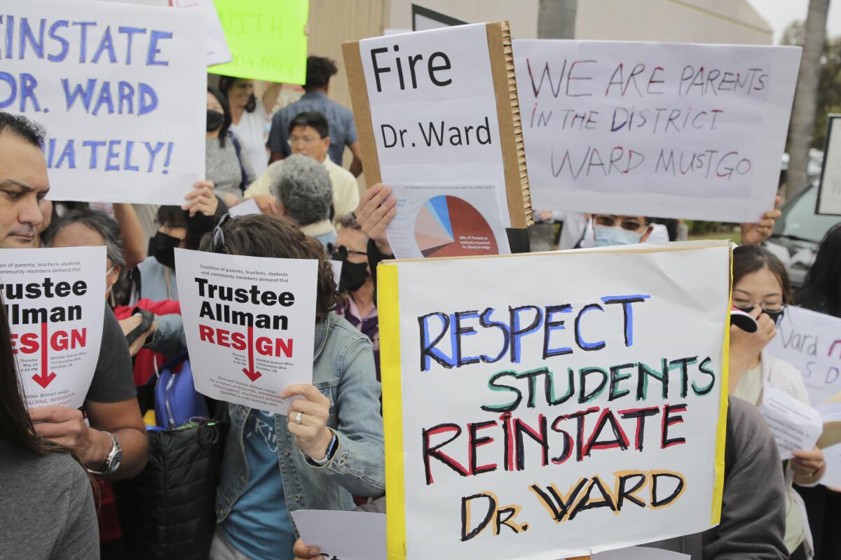 San Dieguito Union High School District residents holding signs with different opinions on Superintendent Cheryl James-Ward.