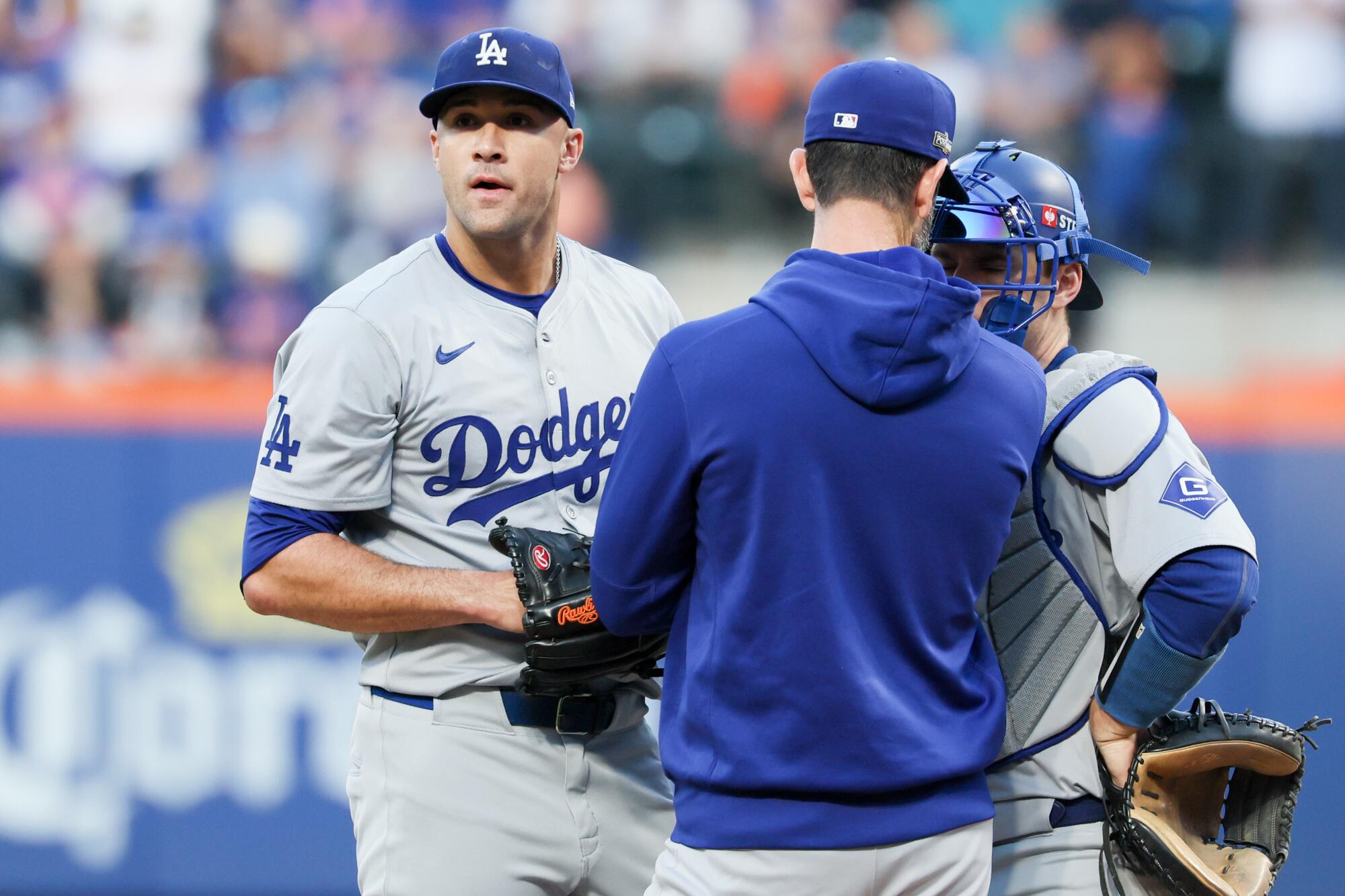 Dodgers pitcher Jack Flaherty, left, speaks with pitching coach Mark Prior and catcher Will Smith in NLCS Game 5.