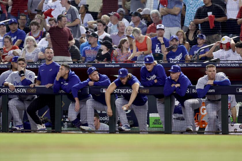 PHOENIX, ARIZONA - OCTOBER 11: Members of the Los Angeles Dodgers look on from the dugout in the ninth inning against the Arizona Diamondbacks during Game Three of the Division Series at Chase Field on October 11, 2023 in Phoenix, Arizona. (Photo by Elsa/Getty Images)