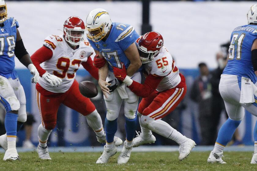 Chargers quarterback Philip Rivers is sacked by Chiefs defensive end Frank Clark (55) and defensive tackle Joey Ivie (93) during a game Nov. 18 at Estadio Azteca in Mexico City.