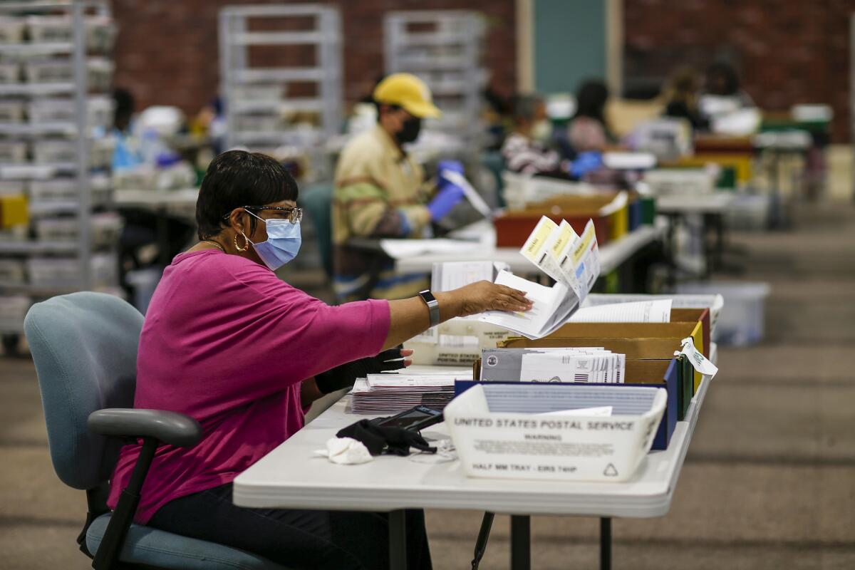 People process ballots at individual desks at a Los Angeles County facility in the City of Industry.