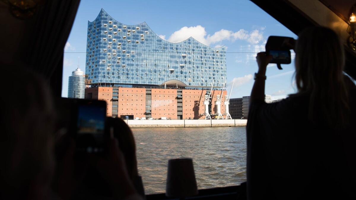 Passengers on a port tour of Hamburg, Germany, snap photos of the Elbphilharmonie concert hall last month. (Carsten Koall / EPA)